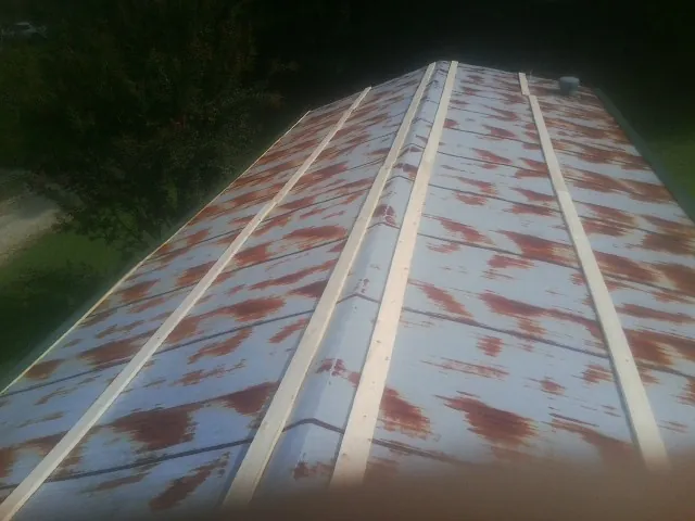 Rusted metal roof panels with new wood purlins before replacement — Storm Damage Roof Repair in Selma by Roofing Brothers
